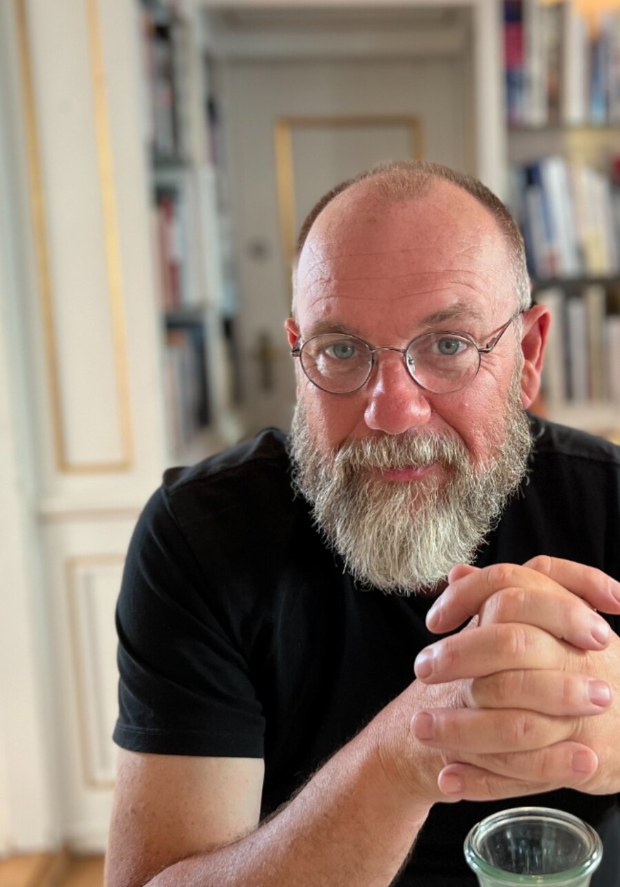 Gordon Poad seated in a book-lined room